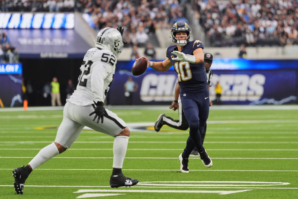 Los Angeles Chargers quarterback Justin Herbert (10) looks to pass as Las Vegas Raiders linebacker Elandon Roberts (52) defends during the second half of an NFL football game, Sunday, Nov. 30, 2025, in Inglewood, Calif. (AP Photo/Jae C. Hong)
