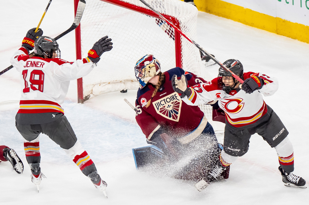 Ottawa Charge's Rebecca Leslie (37) celebrates her goal on Montreal Victoire goaltender Ann-Renee Desbiens (35) with teammate Brianne Jenner (19) during the third period PWHL playoff hockey action in Laval, Quebec, on Thursday, May 14, 2026. (Christopher Katsarov/The Canadian Press via AP)
