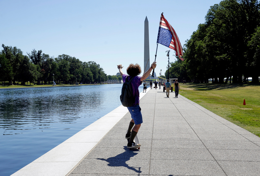 A man with an upside-down U.S. flag is seen near the Reflecting Pool, Wednesday, June 24, 2026, in Washington. (AP Photo/Rahmat Gul)