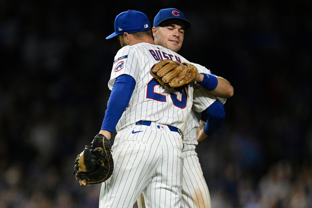 Chicago Cubs' Michael Bush (29) and Matt Shaw, back, celebrate after defeating the New York Mets in a baseball game Wednesday, Sept. 24, 2025, in Chicago. (AP Photo/Paul Beaty)