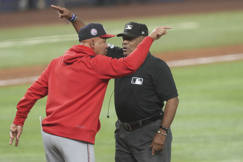 Washington Nationals interim manager Miguel Cairo (22) disputes a call with umpire Laz Diaz (63) during the sixth inning of a baseball game against the Miami Marlins Wednesday, Sept. 10, 2025, in Miami. (AP Photo/Marta Lavandier)