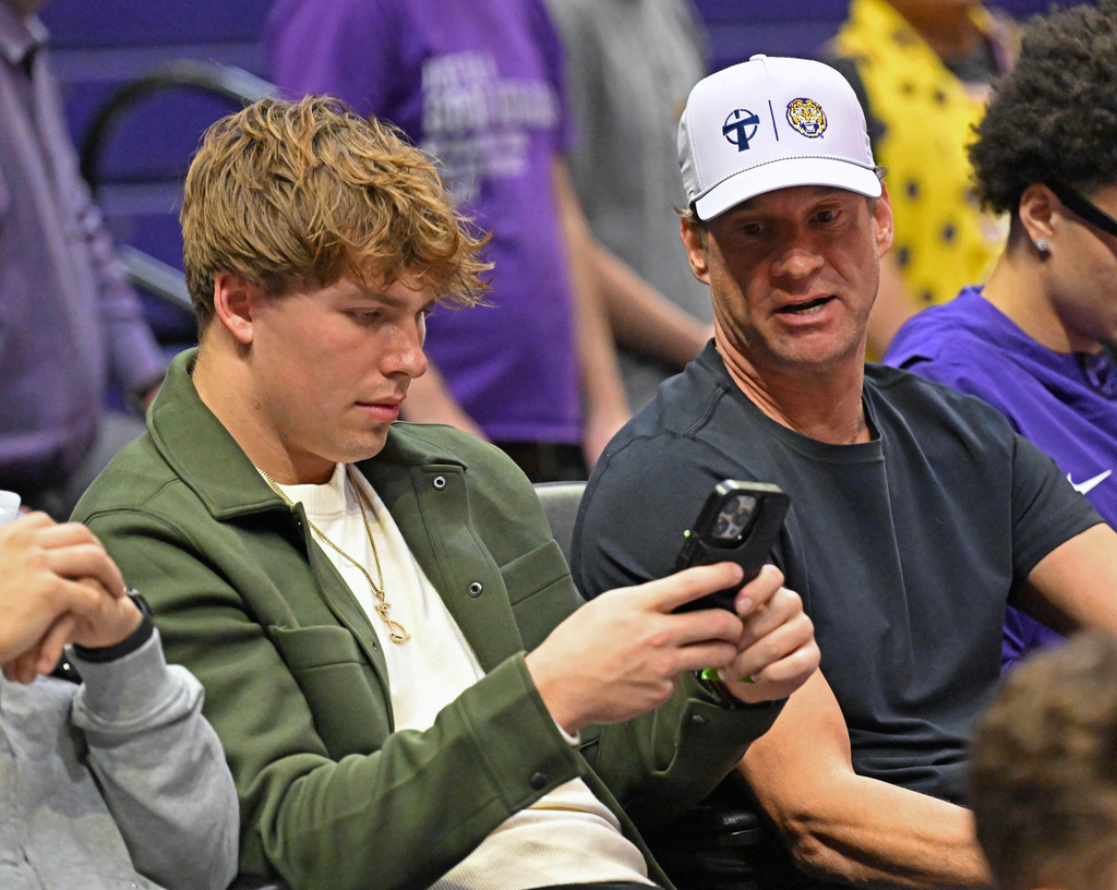 Sam Leavitt, left, and LSU football head coach Lane Kiffin chat as LSU hosts South Carolina in the second half of an NCAA college basketball game in Baton Rouge, La., on Tuesday, Jan. 6, 2026. (Hilary Scheinuk/The Advocate via AP)