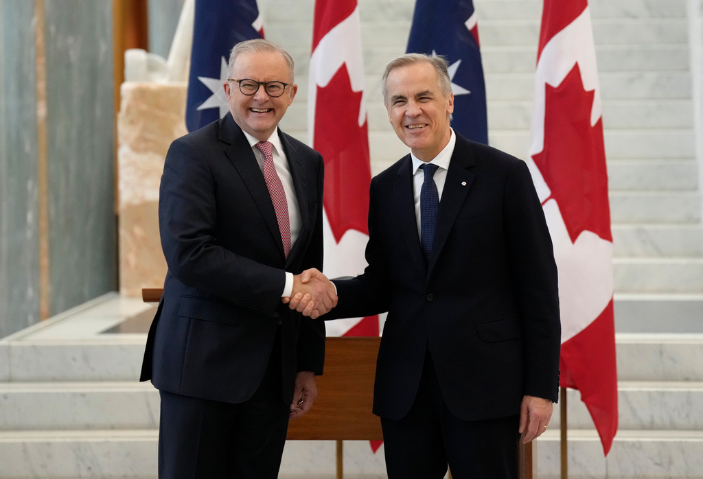 Canada's Prime Minister Mark Carney, right, shakes hands with Australian Prime Minister Anthony Albanese as he arrives at Parliament in Canberra, Australia, Thursday, March 5, 2026. (Adrian Wyld/The Canadian Press via AP)