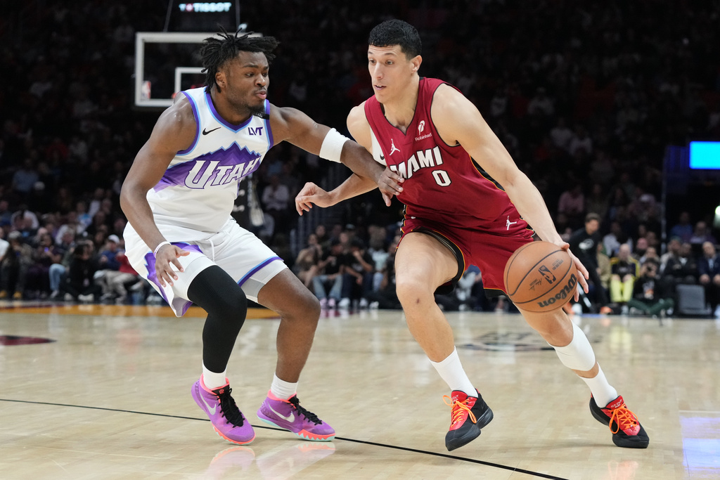 Miami Heat forward Simone Fontecchio (0) dribbles the ball as Utah Jazz guard Isaiah Collier (8) defends during the first half of an NBA basketball game Monday, Feb. 9, 2026, in Miami. (AP Photo/Marta Lavandier)