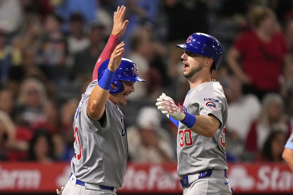 Chicago Cubs' Kyle Tucker, right, is congratulated by Reese McGuire after hitting a three-run home run during the sixth inning of a baseball game against the Los Angeles Angels, Saturday, Aug. 23, 2025, in Anaheim, Calif. (AP Photo/Mark J. Terrill)