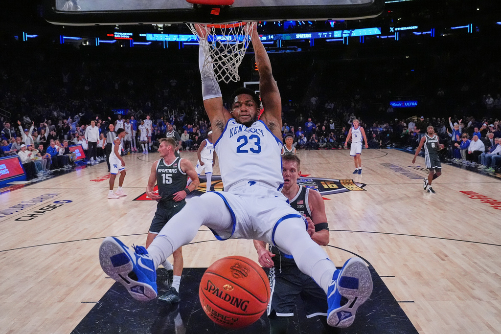 Kentucky's Mouhamed Dioubate, center, dunks the ball in front of Michigan State's Jaxon Kohler, right, and Carson Cooper, left, during the first half of an NCAA college basketball game Tuesday, Nov. 18, 2025, in New York. (AP Photo/Frank Franklin II)