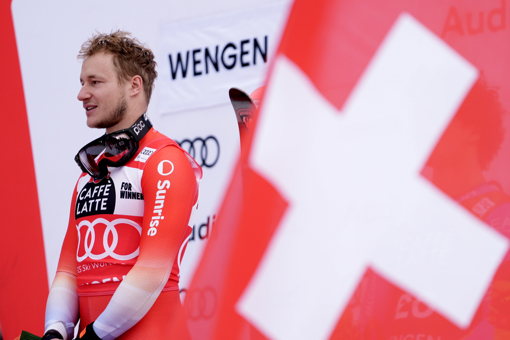 Switzerland's Marco Odermatt listens to the national anthem on the podium after winning an alpine ski, men's World Cup downhill, in Wengen, Switzerland, Saturday, Jan. 17, 2026. (AP Photo/Giovanni Zenoni)