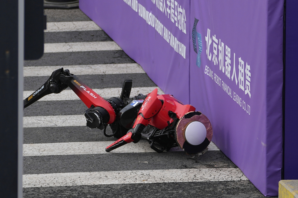 A robot crashes against a board after crossing the finish line in the Beijing E-Town Half Marathon and Humanoid Robot Half-Marathon held in the outskirts of Beijing, Sunday, April 19, 2026. (AP Photo/Andy Wong)