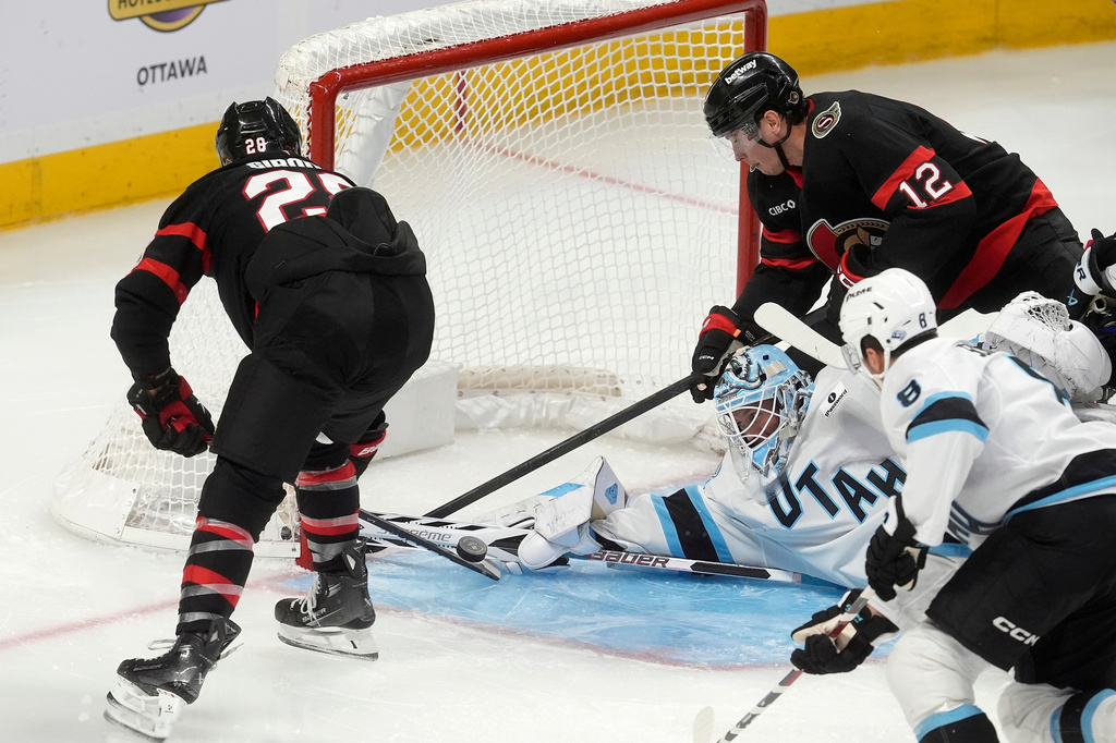 Ottawa Senators right wing Claude Giroux (28) and center Shane Pinto (12) try and put the puck past Utah Mammoth goaltender Vitek Vanecek, bottom left, during third-period NHL hockey game action in Ottawa, Ontario, Sunday, Nov. 9, 2025. (Adrian Wyld/The Canadian Press via AP)