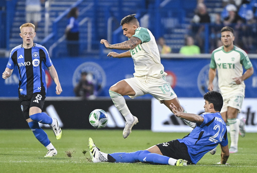 Austin FC's Myrto Uzuni (10) leaps over CF Montreal's Efrain Morales (24) during first-half MLS soccer match action in Montreal, Saturday, Aug. 23, 2025. (Graham Hughes/The Canadian Press via AP)
