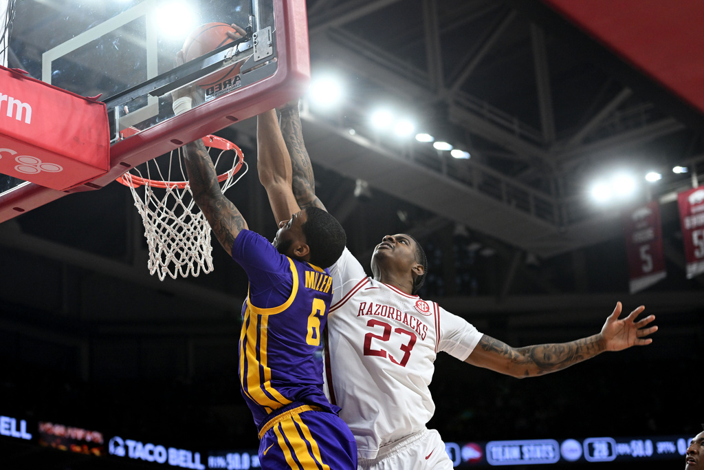 LSU forward Robert Miller III (6) dunks the ball over Arkansas forward Nick Pringle (23) during the first half of an NCAA college basketball game Saturday, Jan. 24, 2026, in Fayetteville, Ark. (AP Photo/Michael Woods)