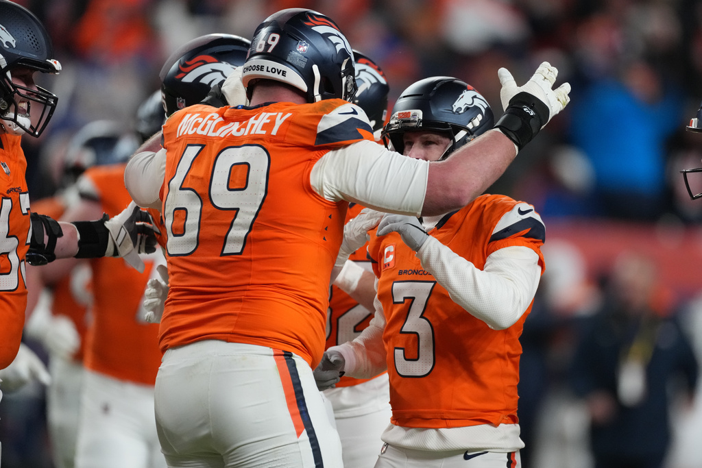 Denver Broncos place kicker Wil Lutz (3) celebrates with offensive tackle Mike McGlinchey (69) after kicking a filed goal during overtime of an NFL divisional round playoff football game against the Buffalo Bills, Wednesday, Jan. 17, 2024, in Denver. (AP Photo/David Zalubowski)
