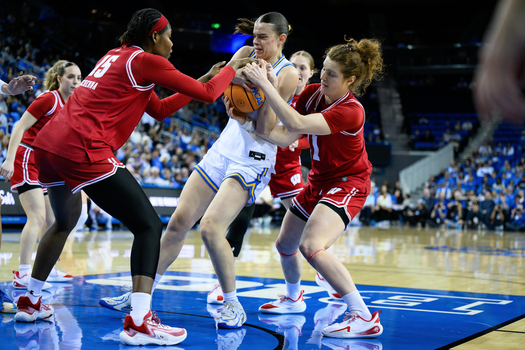 UCLA forward Gabriela Jaquez, center, Wisconsin forward Gift Uchenna (15) and guard Jovana Spasovski, right, vie for the ball during the first half of an NCAA college basketball game, Sunday, Feb. 22, 2026, in Los Angeles. (AP Photo/William Liang)