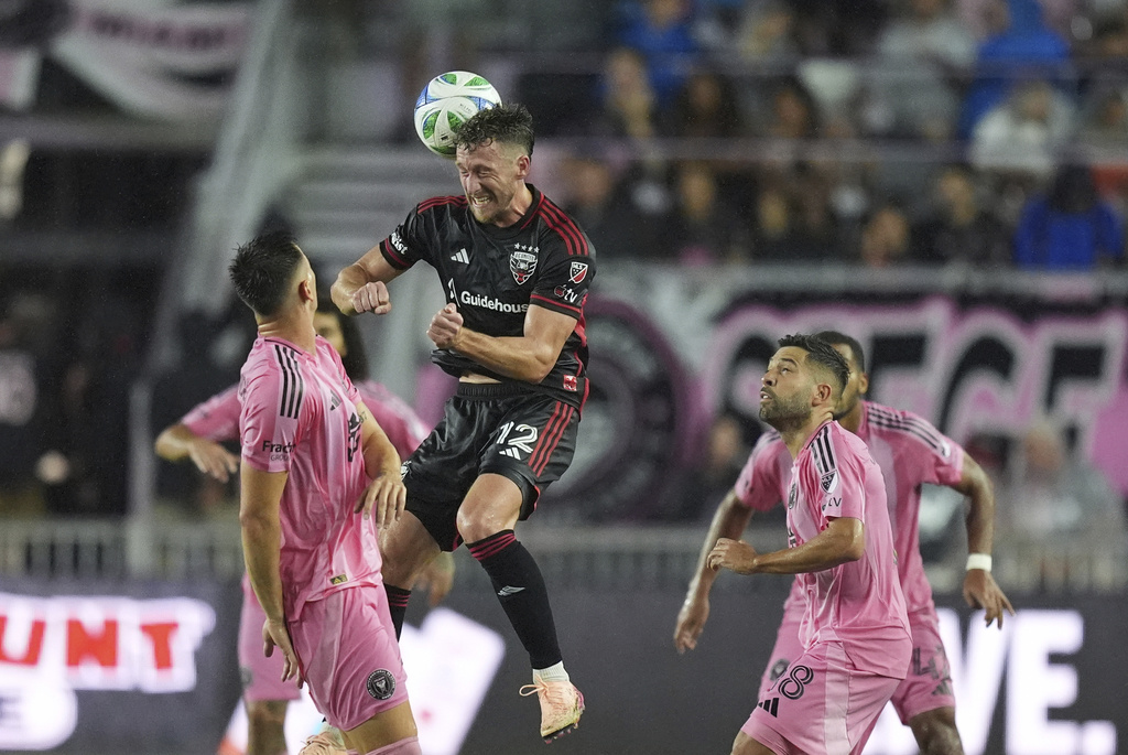 D.C. United defender Conner Antley (12) heads the ball over Inter Miami forward Tadeo Allende, left, and defender Jordi Alba (18) during the first half of an MLS soccer match, Saturday, Sept. 20, 2025, in Fort Lauderdale, Fla. (AP Photo/Rebecca Blackwell)