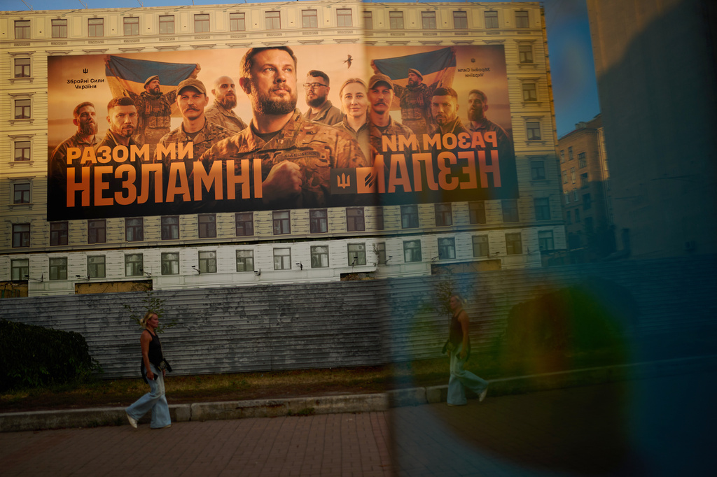 A sign featuring images of Ukrainian soldiers and the Ukrainian phrase: "Together we are unbreakable" covers a building in downtown Kyiv, Ukraine, Sunday, Aug. 30, 2026. (AP Photo/Francisco Seco)