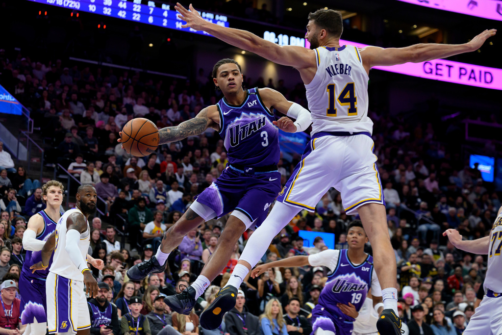 Utah Jazz guard Keyonte George (3) passes the ball around the defense of Los Angeles Lakers forward Maxi Kleber (14) during the second half of an NBA basketball game, Sunday, Nov. 23, 2025, in Salt Lake City. (AP Photo/Tyler Tate)