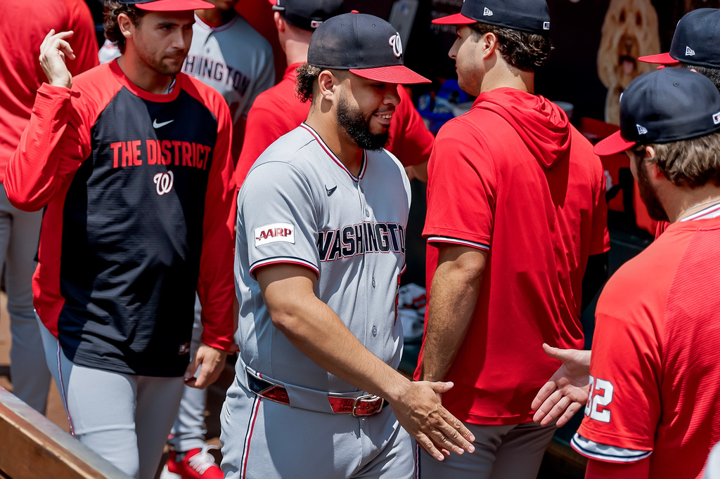 Washington Nationals first baseman Luis García Jr., center, greets teammates in the dugout after he was scratched from the starting lineup before a baseball game against the Atlanta Braves, Sunday, Aug. 2, 2026, in Atlanta. (AP Photo/Erik S. Lesser)