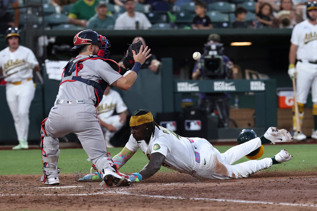 Boston Red Sox catcher Connor Wong, left, attempts to get Athletics' Lawrence Butler (4) out at home plate during the sixth inning of a baseball game Thursday, July 30, 2026, in West Sacramento, Calif. (AP Photo/Sara Nevis)
