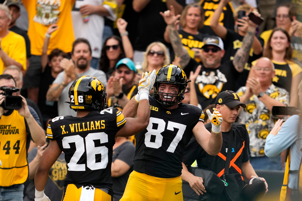 Iowa tight end Addison Ostrenga (87) celebrates with teammate running back Xavier Williams (26) after scoring a touchdown during the first half of an NCAA college football game against Northern Iowa in Iowa City, Iowa, Saturday, Sept. 19, 2026. (AP Photo/Charlie Neibergall)