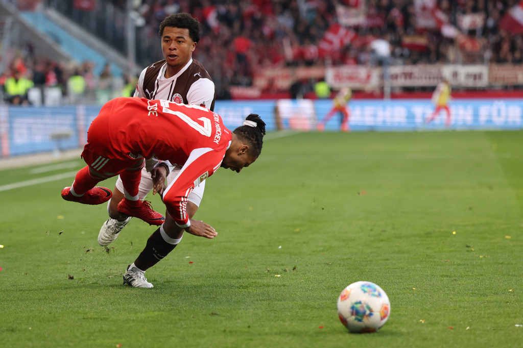 Bayern's Michael Olise is challenged by FC St. Pauli's Joel Chima Fujita during the German Bundesliga soccer match between FC St. Pauli and Bayern Munich in Hamburg, Germany, Saturday, April 11, 2026. (Christian Charisius/dpa via AP)
