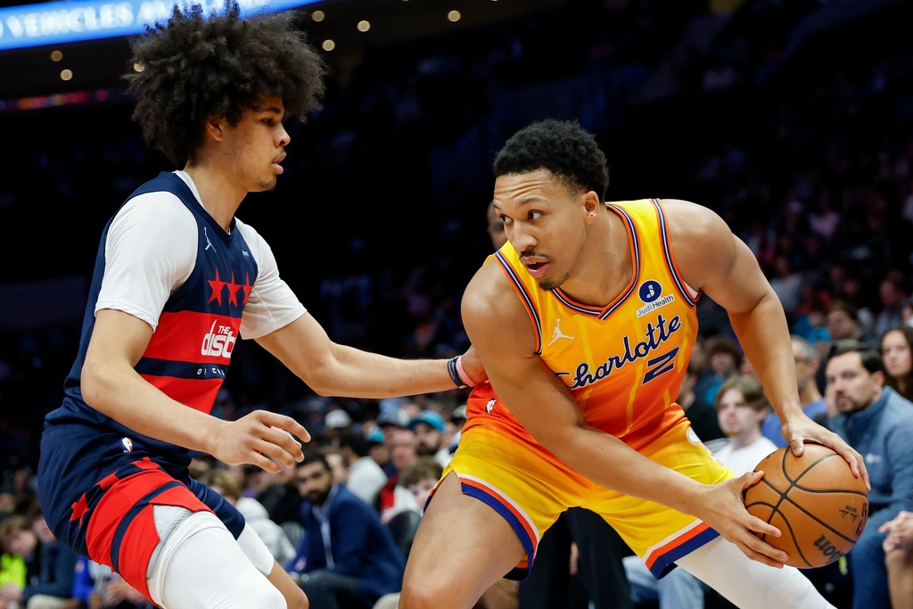 Charlotte Hornets forward Grant Williams (2) looks to drive against Washington Wizards guard Kyshawn George during the first half of an NBA basketball game in Charlotte, N.C., Saturday, Jan. 24, 2026. (AP Photo/Nell Redmond).