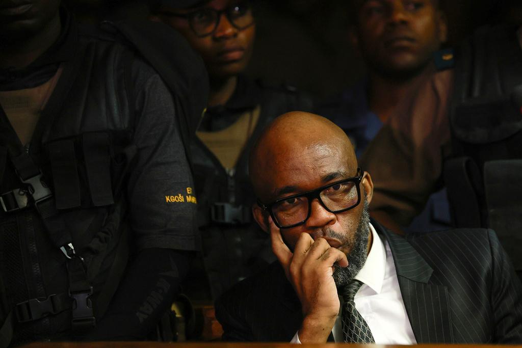 An alleged crime boss Vusimuzi "Cat" Matlala with some of the 12 senior police officers appearing at the magistrate court in Pretoria, South Africa, Wednesday, March 25, 2026, on fraud and corruption charges. (AP Photo)