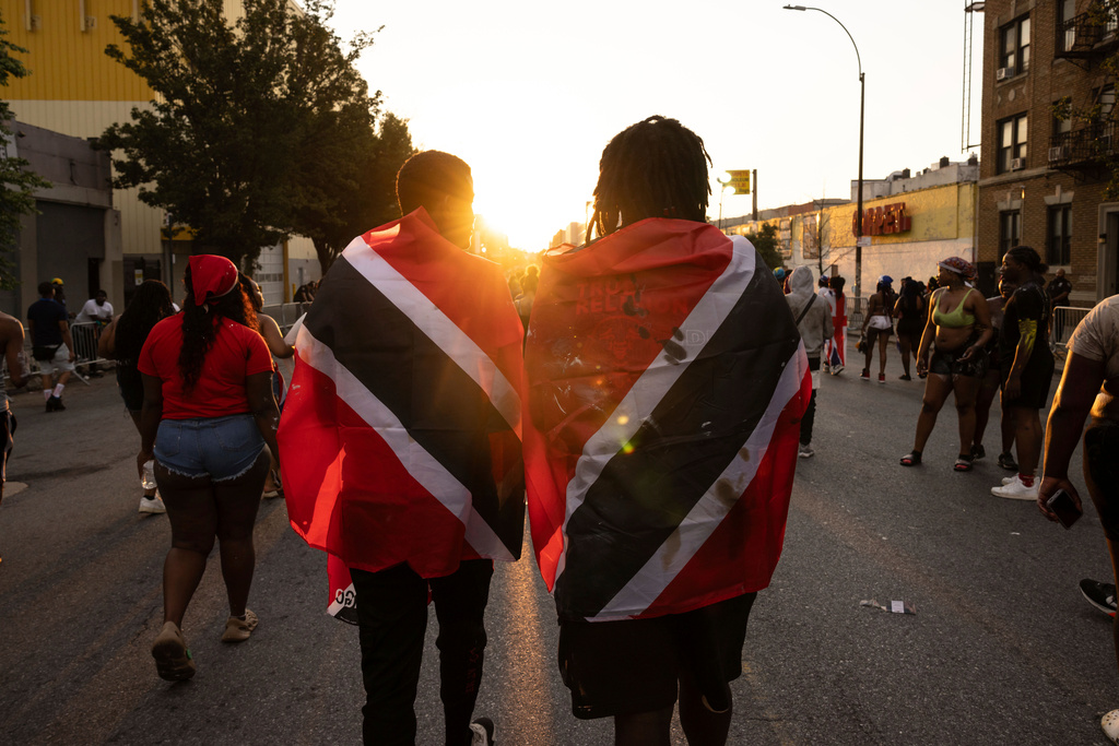FILE - People with Trinidad and Tobago flag are seen during J'ouvert celebration, Sept. 4, 2023, in the Brooklyn borough of New York. (AP Photo/Yuki Iwamura, File)