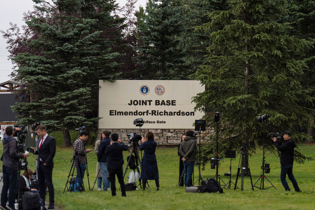 Members of the media stand outside Joint Base Elmendorf-Richardson in Anchorage, Alaska, Thursday, Aug. 14, 2025, ahead of a meeting between President Donald Trump and Russia's President Vladimir Putin. (AP Photo/Jae C. Hong)