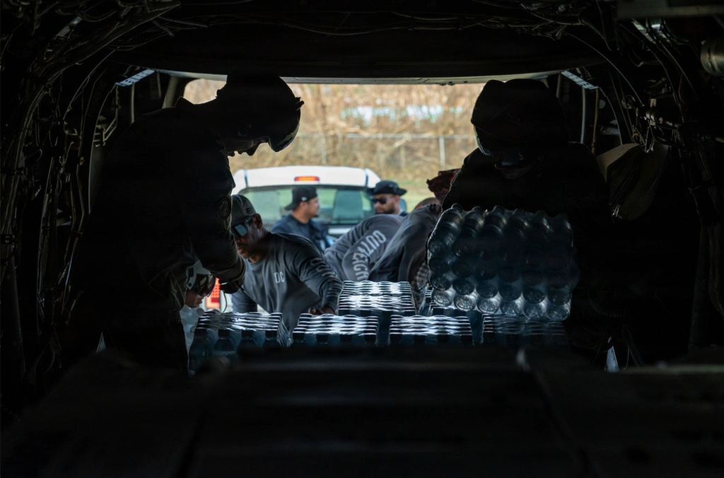 In this photo provided by U.S. Marine Corps , U.S. Marines with Marine Medium Tiltrotor Squadron (VMM) 163 (Reinforced), 11th Marine Expeditionary Unit, and local volunteers, unload water bottles from an MV-22B Osprey on the island of Saipan, April 18, 2026. (Cpl. Oliver Nisbet/U.S. Marine Corps via AP )