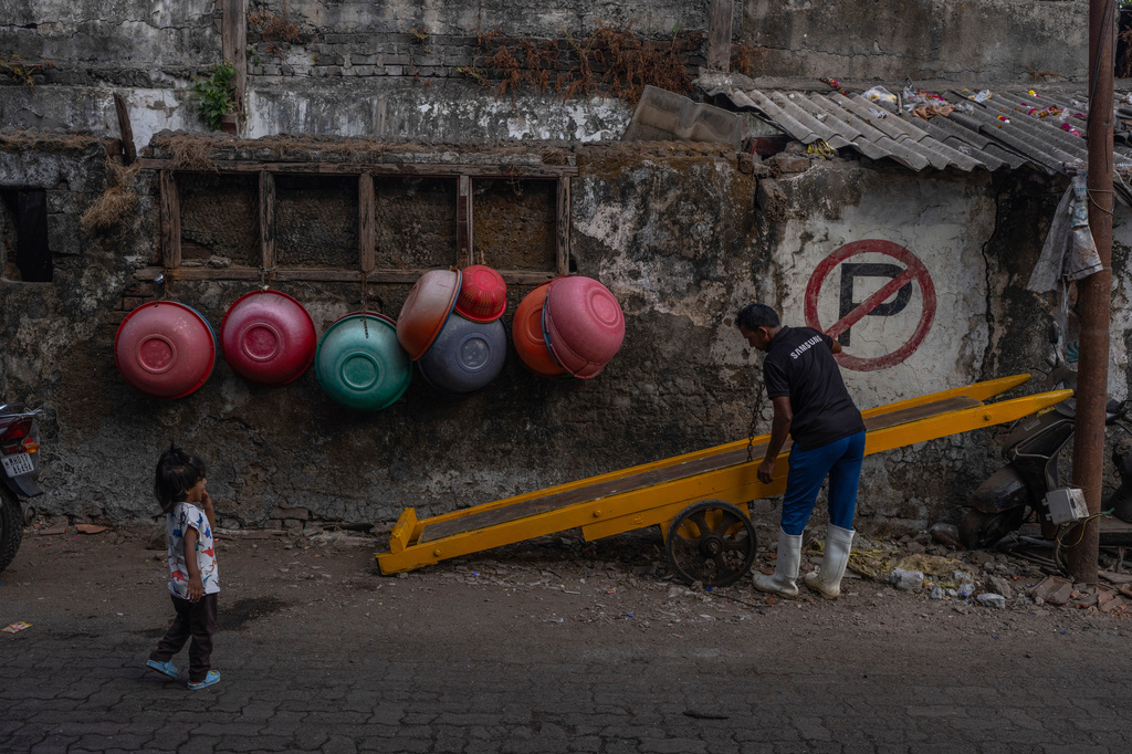 Empty fishing baskets are seen hanging on the wall outside a fish market at Sassoon Dock In Mumbai, India, Wednesday, April 8, 2026. (AP Photo/Rafiq Maqbool)