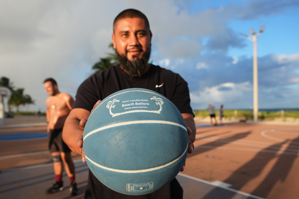 Ozzie McRea holds a basketball with the name Fort Lauderdale Beach Ballers, a group that regularly meets at the basketball courts on the Fort Lauderdale Beach Park, the site of proposed pickleball courts as part of a new luxury development, Oct. 8, 2025, in Fort Lauderdale, Fla. (AP Photo/Lynne Sladky)