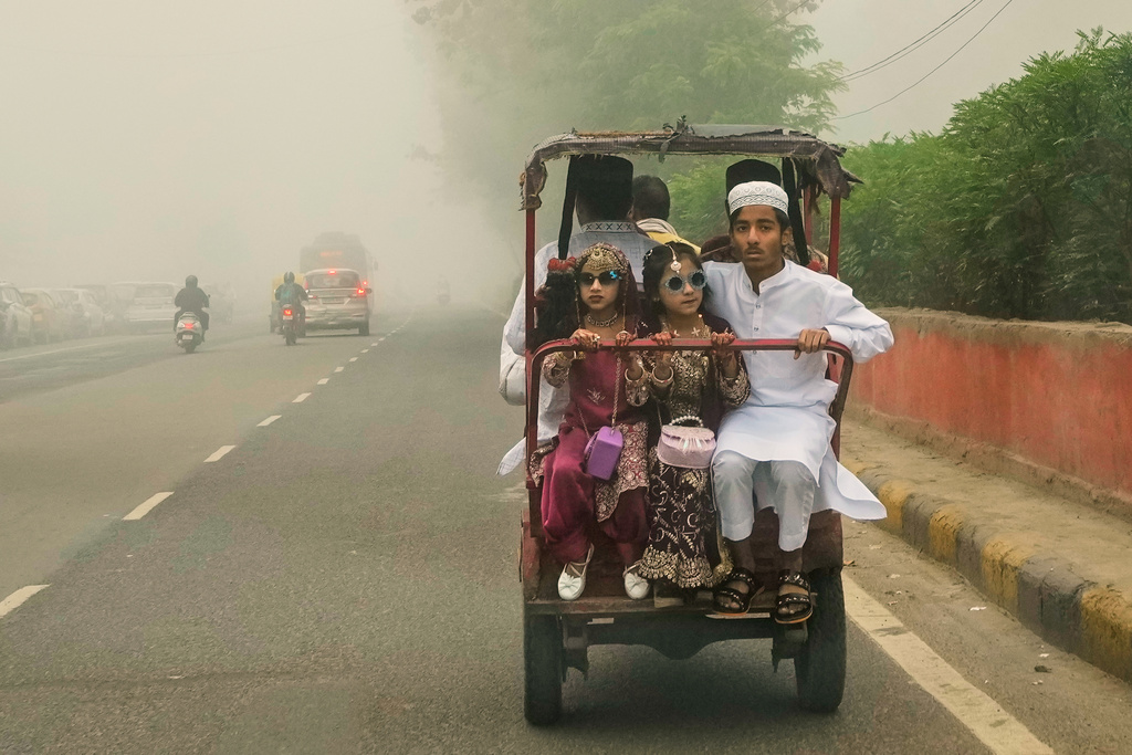 A family leaves amidst morning fog after performing Eid al-Fitr prayers to mark the end of the holy fasting month of Ramadan at the Jama Masjid in New Delhi, India, Saturday, March 21, 2026. (AP Photo/Manish Swarup)