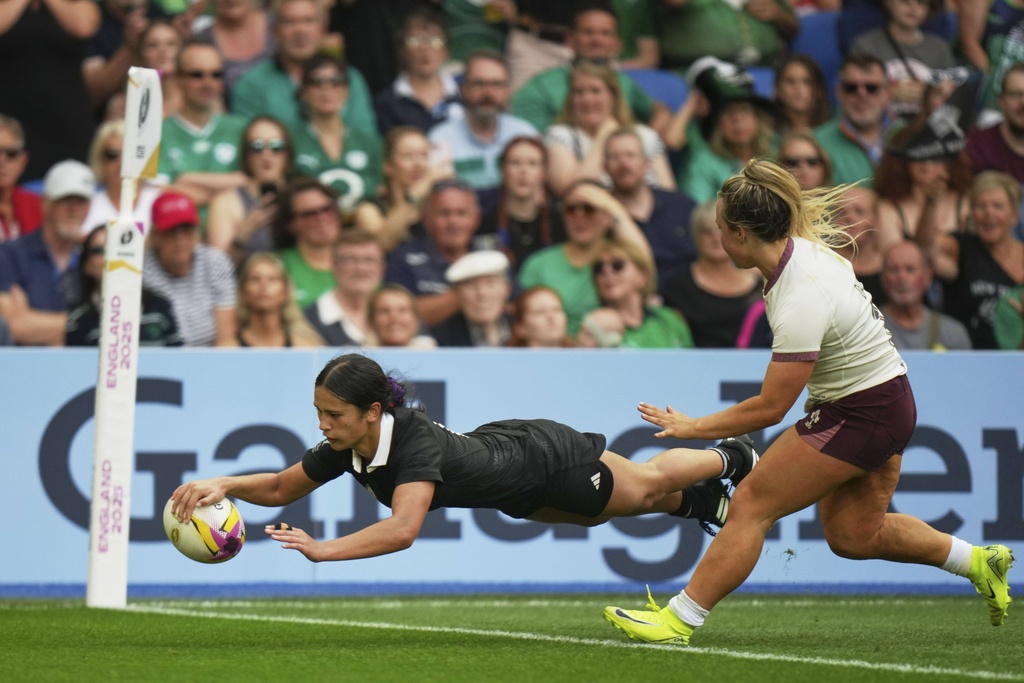 New Zealand's Braxton Sorensen-McGee, left, scores a try as Ireland's Aoife Wafer, tries to defend during the Women's Rugby World Cup 2025 Pool C match between New Zealand and Ireland in Brighton and Hove, England, Sunday, Sept. 7, 2025. (AP Photo/Alastair Grant)