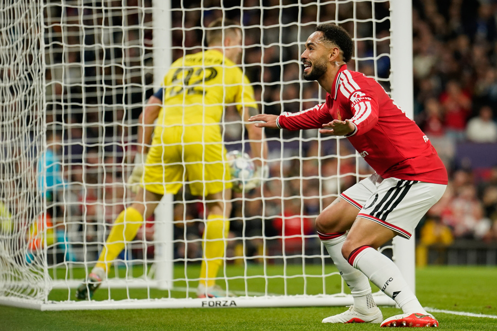 Manchester United's Matheus Cunha celebrates after he scored the opening goal against Sabah's goalkeeper Stas Pokatilov, left, during the Champions League opening phase soccer match between Manchester United and Sabah FK in Manchester, England, Thursday, Sept. 10, 2026. (AP Photo/Dave Thompson)