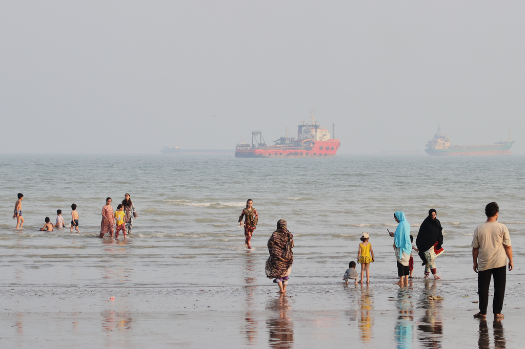 People spend time at a beach as commercial vessels are anchored in the Strait of Hormuz off Bandar Abbas, Iran, Monday, Aug. 31, 2026. (Razieh Poudat/ISNA via AP)