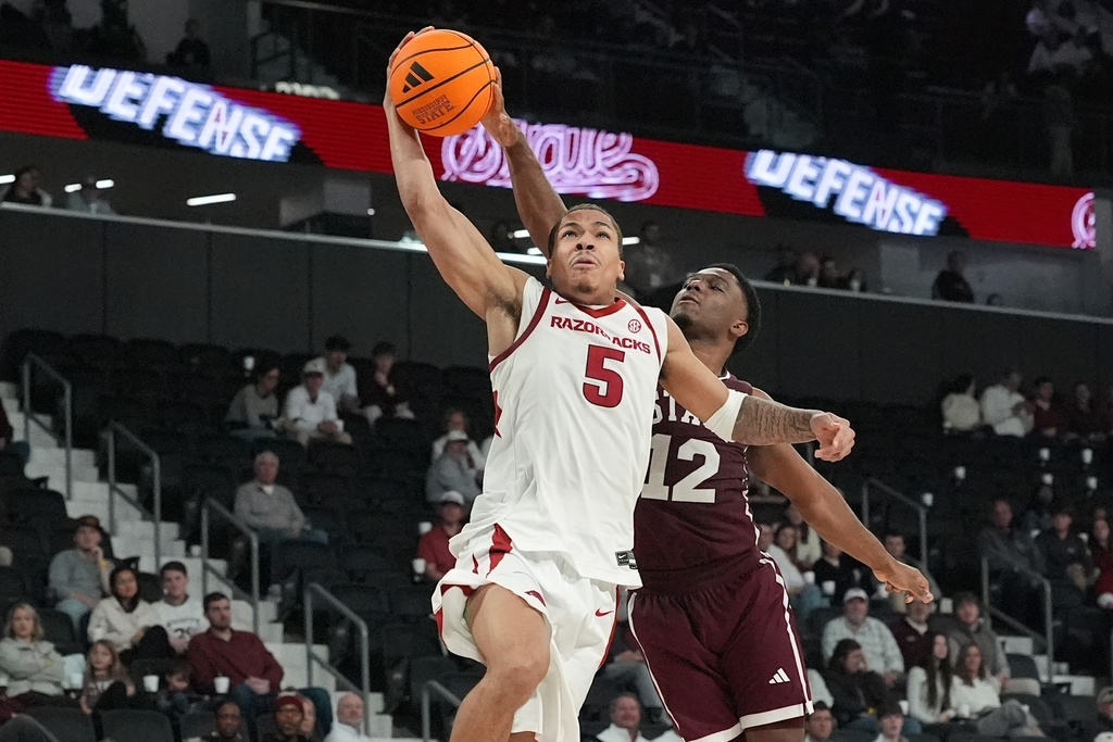 Arkansas guard Darius Acuff Jr. (5) has the ball knocked away by Mississippi State guard Josh Hubbard (12) during the first half of an NCAA college basketball game, Saturday, Feb. 7, 2026, in Starkville, Miss. (AP Photo/Rogelio V. Solis)