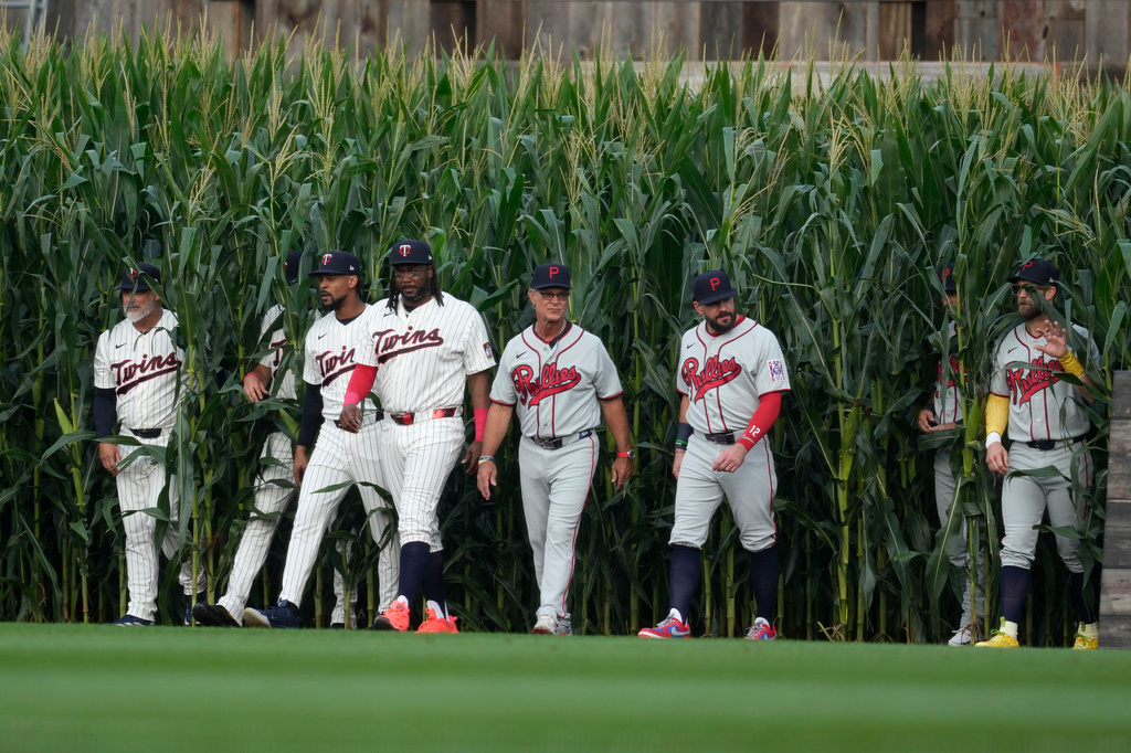 Players walk onto the field before a baseball game between the Minnesota Twins and the Philadelphia Phillies at the Field of Dreams movie site, Thursday, Aug. 13, 2026, in Dyersville, Iowa. (AP Photo/Charlie Neibergall)