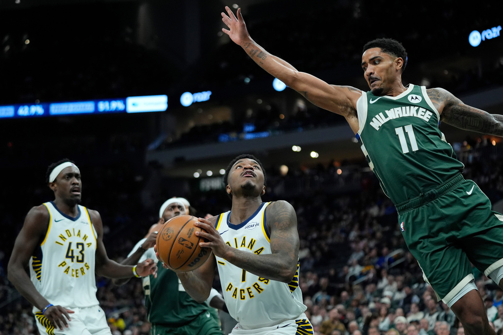 Indiana Pacers' Kam Jones, center, looks to shoot against Milwaukee Bucks' Gary Harris (11) during the first half of an NBA basketball game Friday, Feb. 6, 2026, in Milwaukee. (AP Photo/Aaron Gash)