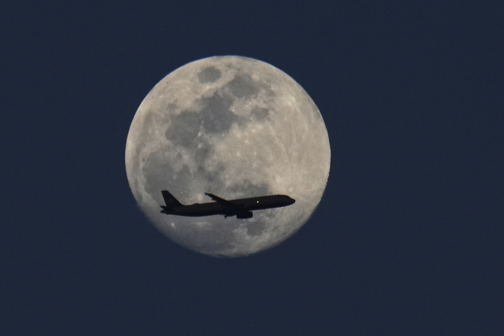 FILE - A waxing gibbous moon is seen as a plane flies by March 12, 2025, in Grand Prairie, Texas. (AP Photo/Julio Cortez, File)