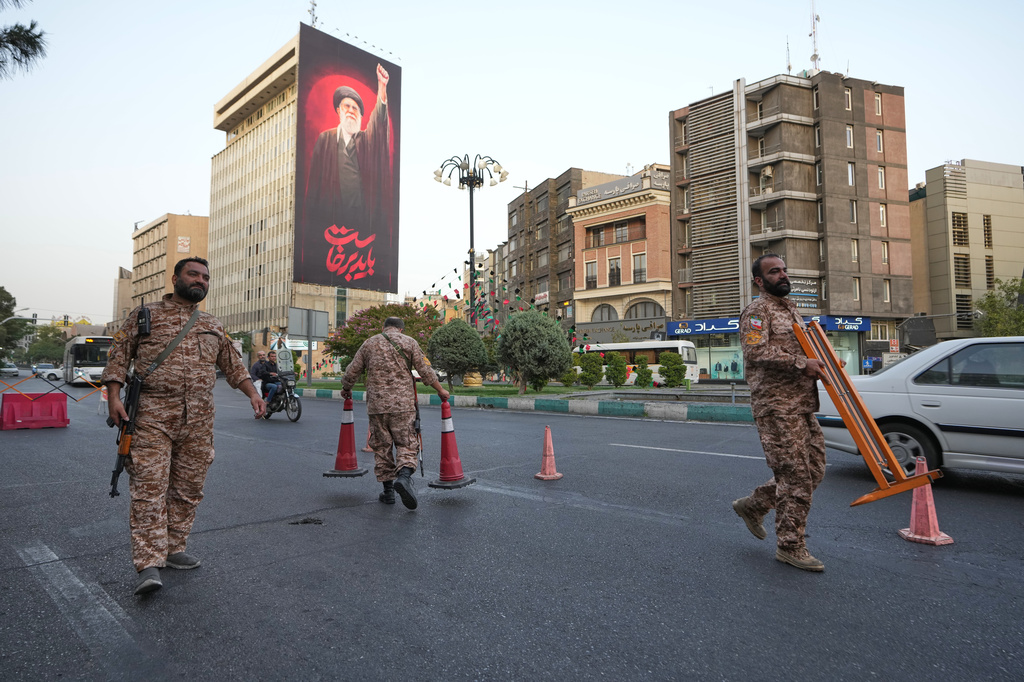Iran's Basij paramilitary forces set up a checkpoint at a square ahead of the funeral ceremonies of slain Supreme Leader Ayatollah Ali Khamenei, shown at the billboard at rear, in Tehran, Iran, Thursday, July 2, 2026. (AP Photo/Vahid Salemi)