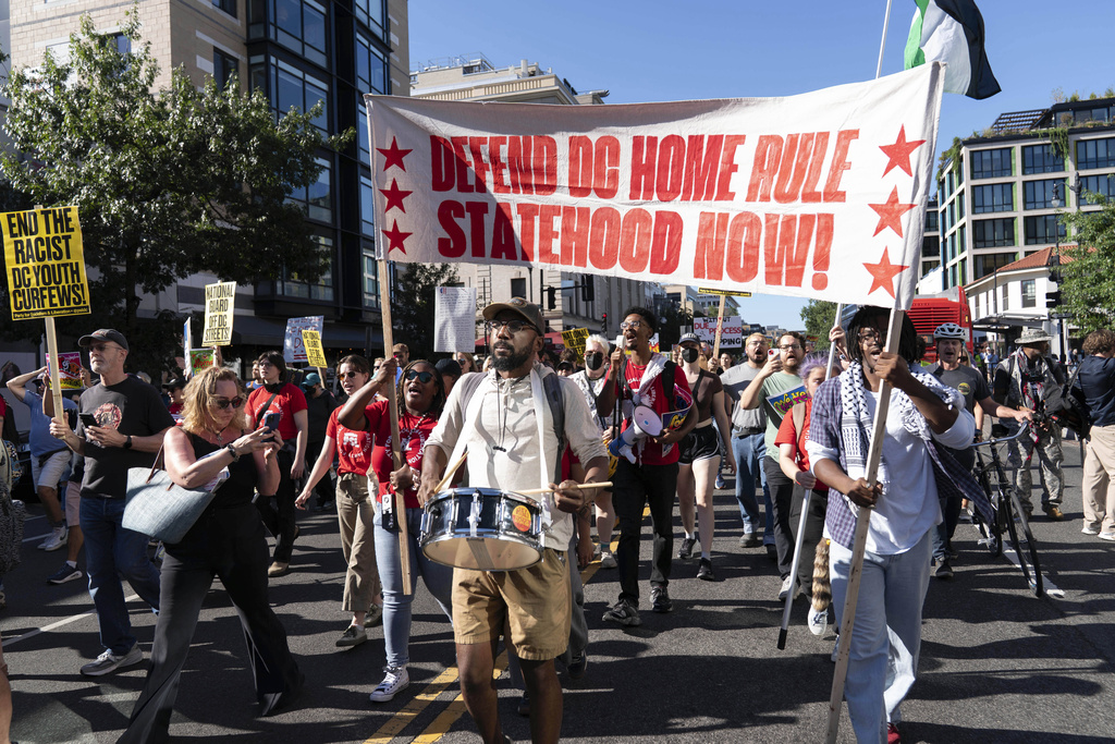 Demonstrators march as they protest against President Donald Trump's use of federal law enforcement and National Guard troops in the city during a rally along the 14th street corridor in northwest Washington, Saturday, Aug. 30, 2025. (AP Photo/Jose Luis Magana)
