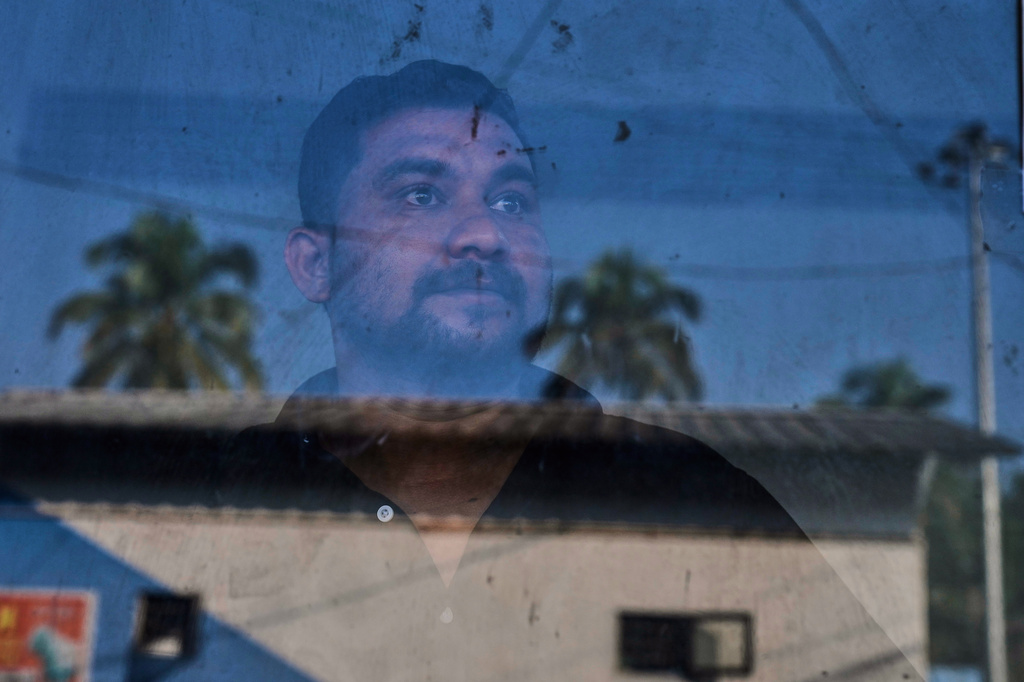 Safeer Mohammed Koorimannil, who was trafficked into scamming, looks out from the window of his CM Fisheries office before starting the day, in Sulthan Bathery in the southern state of Kerala, India, Thursday, March 12, 2026. (AP Photo/Manish Swarup)