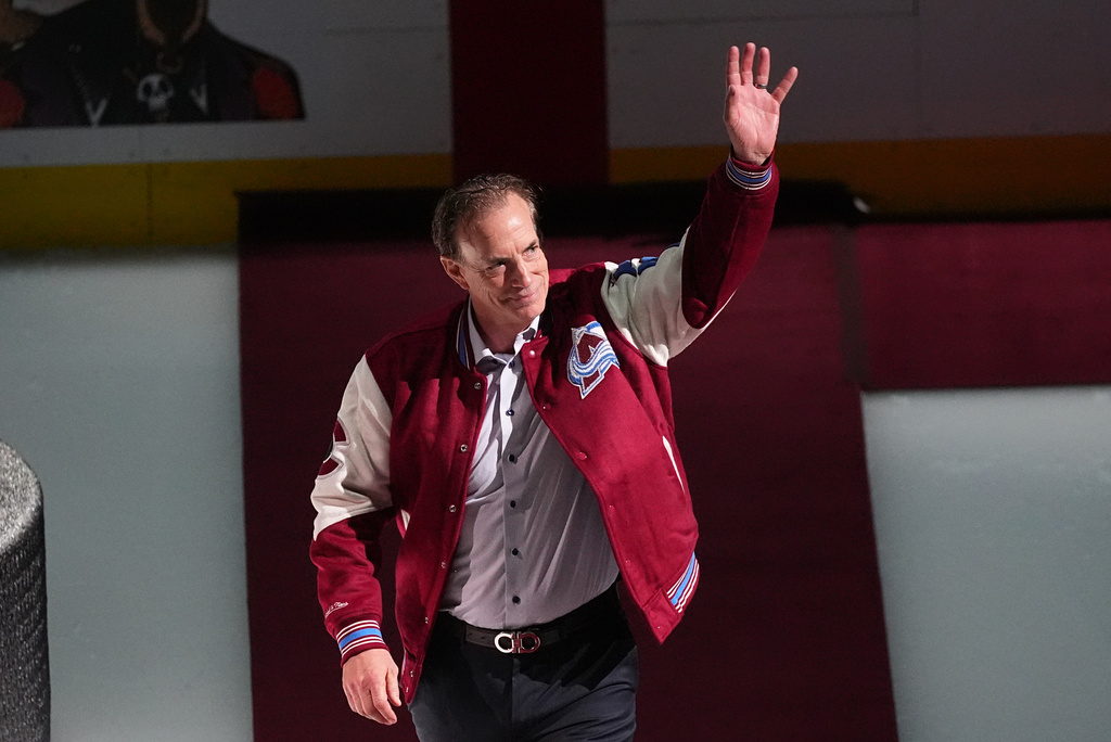 FILE - Joe Sakic, current general manager of the Colorado Avalanche as well as a member of the 1996 Stanley Cup Championship team, waves as he is introduced during a ceremony to mark the 30th anniversary of the win before an NHL hockey game against the Florida Panthers, on Dec. 11, 2025, in Denver. (AP Photo/David Zalubowski, File)