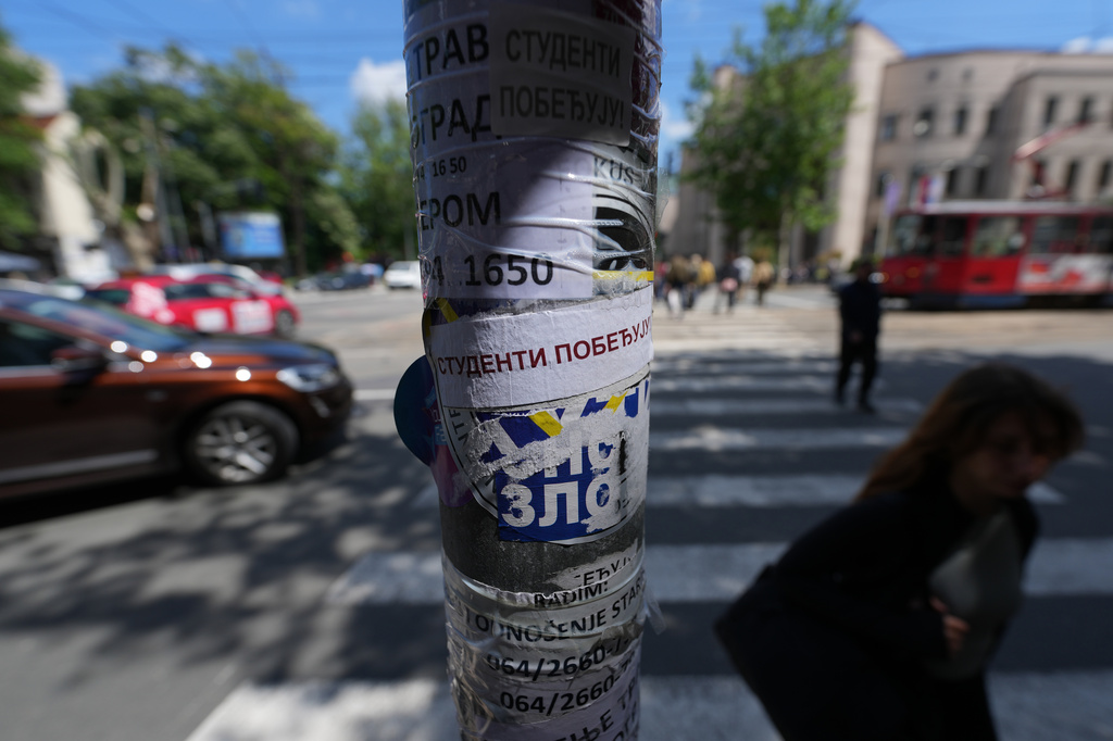 People walk by a lamppost with stickers that read: "Students win" before the first big rally this year of opponents of President Aleksandar Vucic in Belgrade, Serbia, Monday, May 18, 2026. (AP Photo/Darko Vojinovic)