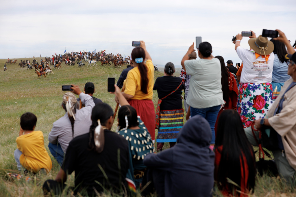Spectators watch the charging event during festivities to commemorate the 150th anniversary of the Battle of the Little Bighorn in Crow Agency, Mont., on Thursday, June 25, 2026. (AP Photo/Tailyr Irvine)