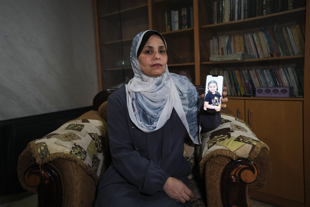 Hind Rajab poses in Gaza City, Wednesday, Aug. 19, 2026, with a photo of her granddaughter, Hind Rajab, a 5-year-old Palestinian girl who was killed alongside her family in Gaza in February 2024. (AP Photo/Jehad Alshrafi)