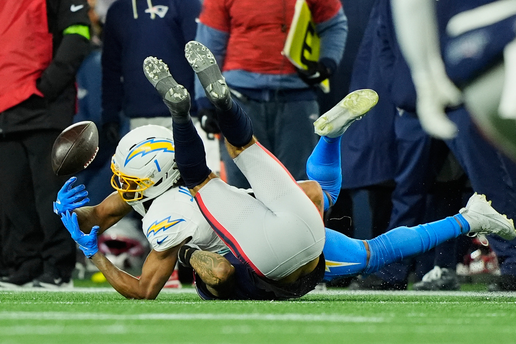 Los Angeles Chargers wide receiver Quentin Johnston (1) can't hold onto a pass while defended by New England Patriots cornerback Christian Gonzalez, bottom, in the second half of an NFL wild-card playoff football game in Foxborough, Mass., Sunday, Jan. 11, 2026. (AP Photo/Robert F. Bukaty)