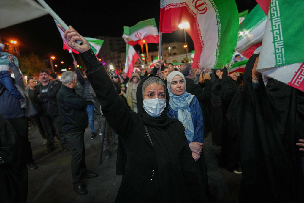 Women hold Iranian flags during a pro-government gathering in a square in Tehran, Iran, Sunday, April 5, 2026. (AP Photo/Francisco Seco)