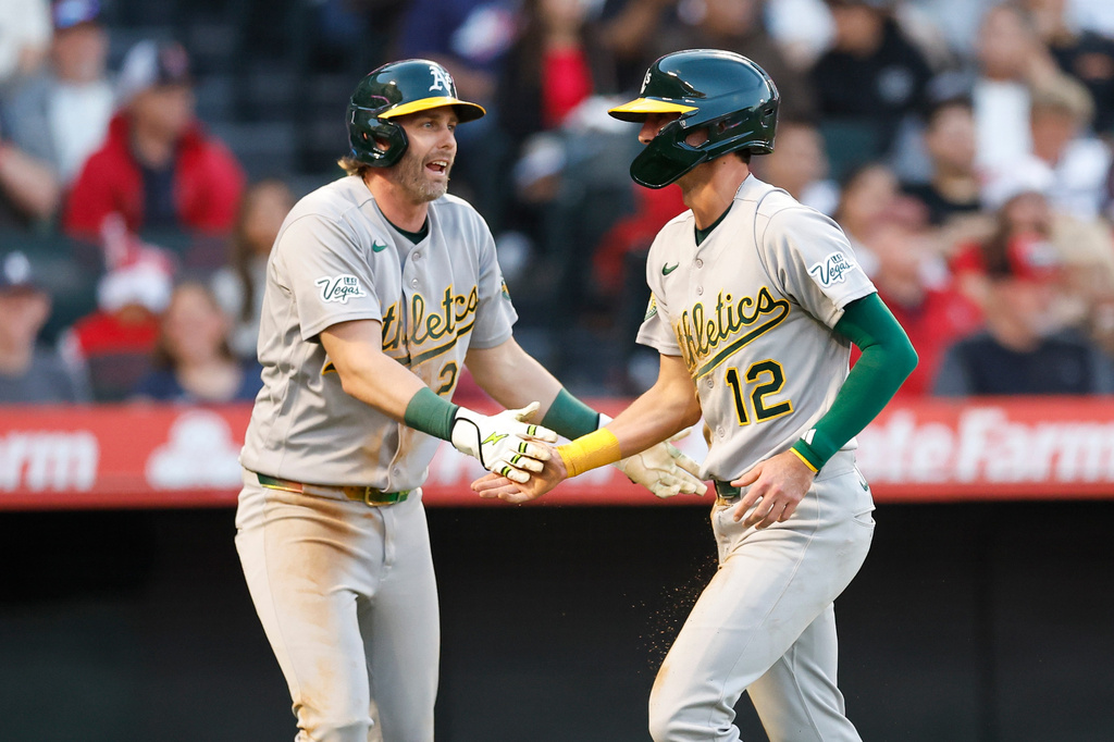 Athletics' Jeff McNeil, left, and Alika Williams (12) react after scoring on a single by Henry Bolte during the fifth inning of a baseball game against the Los Angeles Angels, Friday, June 26, 2026, in Anaheim, Calif. (AP Photo/Caroline Brehman)