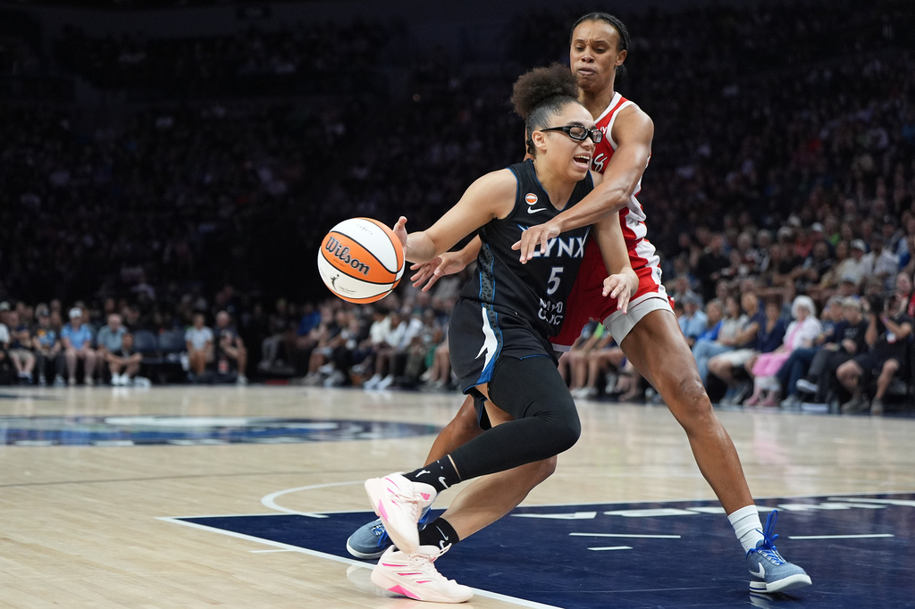 Minnesota Lynx guard Olivia Miles works toward the basket as Las Vegas Aces forward Brianna Turner defends during the first half of a WNBA basketball game in Minneapolis, Saturday, Aug. 8, 2026. (AP Photo/Abbie Parr)